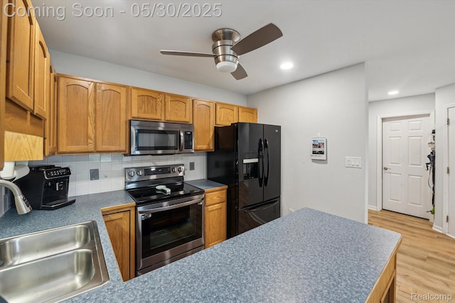 326 Redmaple Ln, Brighton, MI 48116 - kitchen featuring appliances with stainless steel finishes, a sink, tasteful backsplash, a ceiling fan, and light wood-style floors