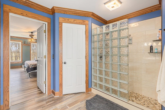 10191 84th St SE, Alto, MI 49302 - bathroom featuring a walk in shower, wood finished floors, ornamental molding, ensuite bathroom, and ceiling fan