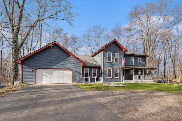 10191 84th St SE, Alto, MI 49302 - view of front of home featuring a porch, asphalt driveway, and a garage