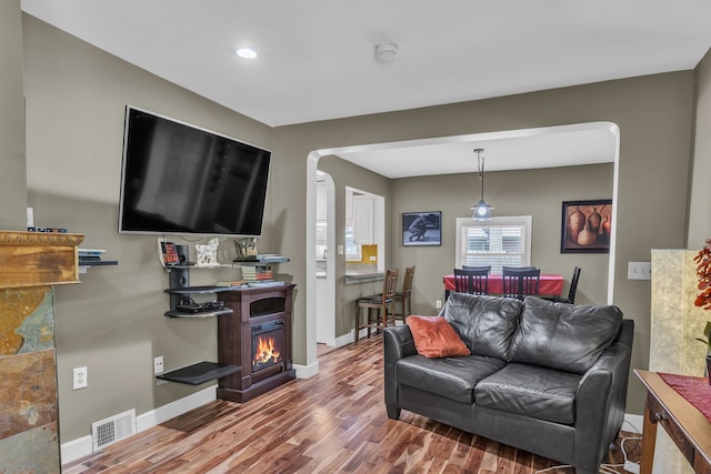 3418 Fieldview Ave, West Bloomfield, MI 48324 - living area with wood finished floors, arched walkways, baseboards, a warm lit fireplace, and recessed lighting