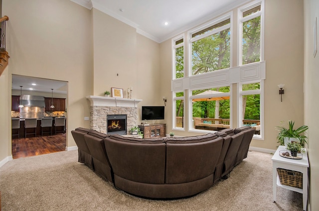 4181 Pavilion Ct, Fenton, MI 48430 - carpeted living area featuring a towering ceiling, baseboards, ornamental molding, a stone fireplace, and recessed lighting