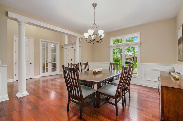 4181 Pavilion Ct, Fenton, MI 48430 - dining room with french doors, dark wood-style flooring, a wainscoted wall, a chandelier, and decorative columns
