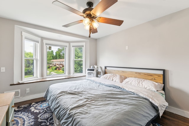 bedroom with wood finished floors, baseboards, and a ceiling fan