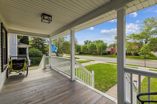 deck featuring covered porch and a lawn