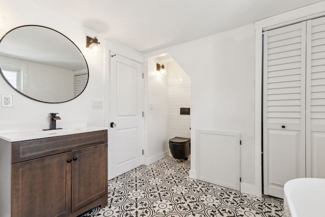 full bath with vanity, toilet, and baseboards
