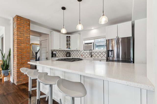 kitchen with stainless steel refrigerator with ice dispenser, decorative backsplash, glass insert cabinets, black gas cooktop, and white cabinets