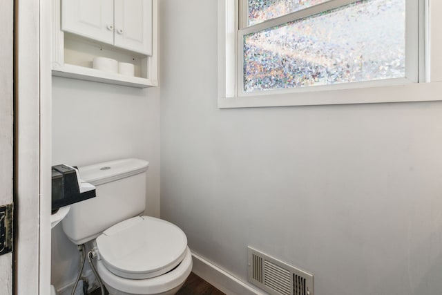 bathroom with baseboards, toilet, and wood finished floors