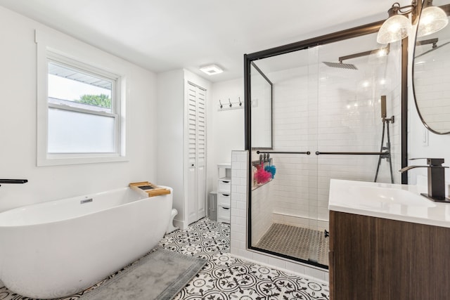 full bath with a stall shower, vanity, a freestanding bath, and tile patterned floors