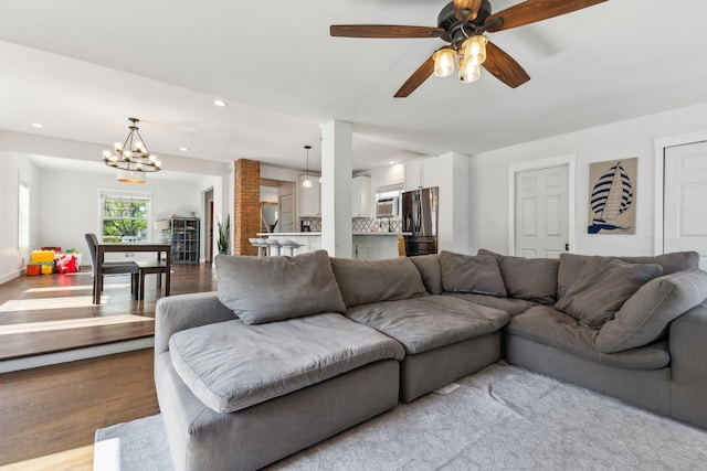 living room featuring wood finished floors, recessed lighting, a chandelier, and ceiling fan