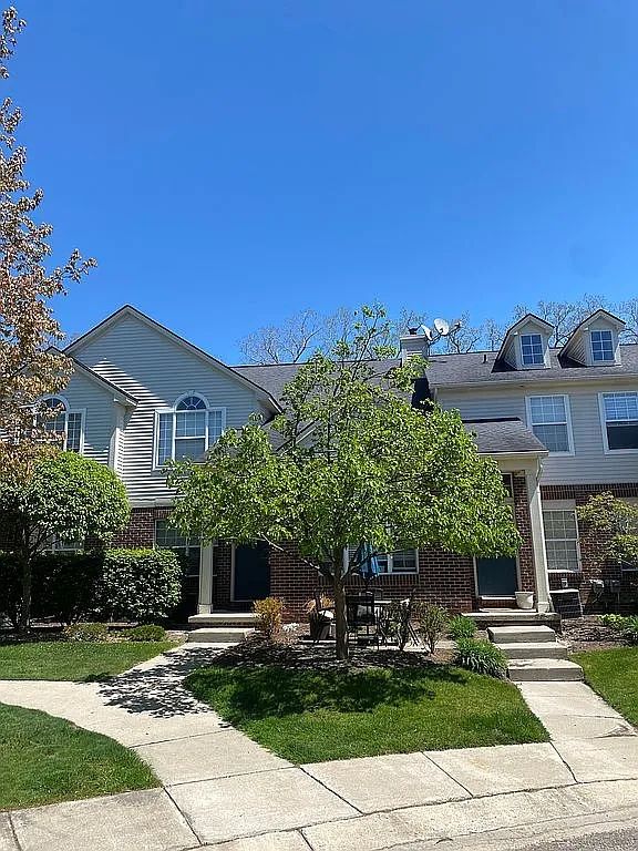 18203 Adri Cir, Walled Lake, MI 48390 - view of front of house with brick siding and a front lawn