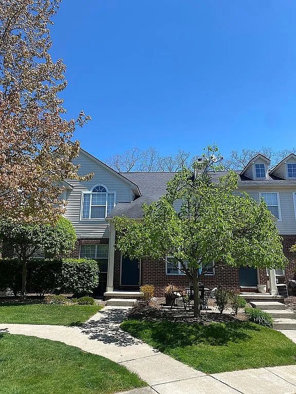 18203 Adri Cir, Walled Lake, MI 48390 - view of front of house with brick siding and a front lawn