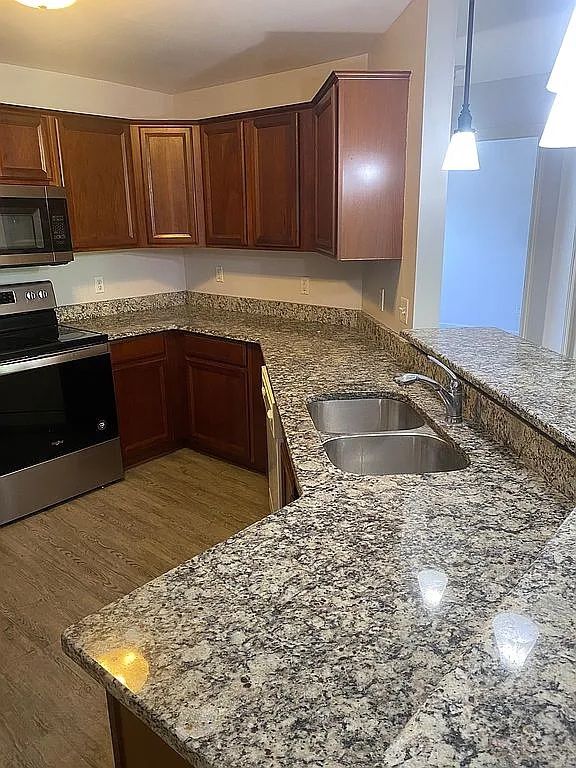 18203 Adri Cir, Walled Lake, MI 48390 - kitchen featuring electric stove, a sink, dark stone countertops, and decorative light fixtures