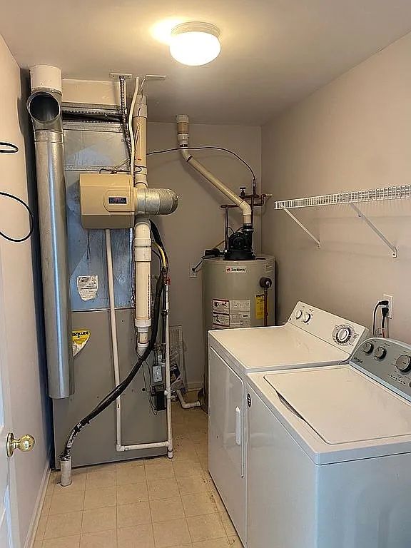 18203 Adri Cir, Walled Lake, MI 48390 - laundry area featuring independent washer and dryer, light tile patterned floors, heating unit, water heater, and baseboards