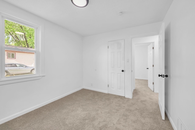 unfurnished bedroom featuring carpet and baseboards
