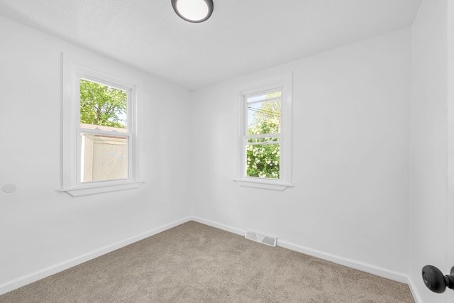carpeted spare room with baseboards