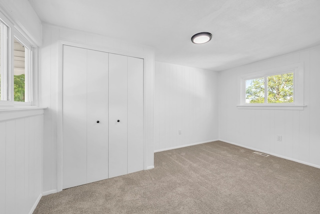 unfurnished bedroom featuring carpet floors and a closet
