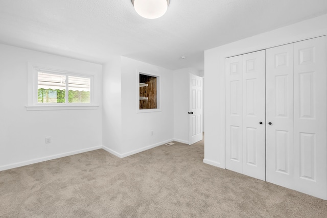 unfurnished bedroom with carpet, baseboards, and a closet