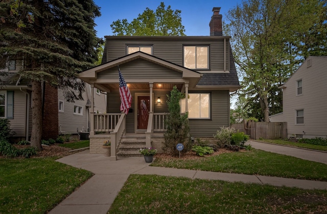 view of front of home with a porch, a chimney, and roof with shingles
