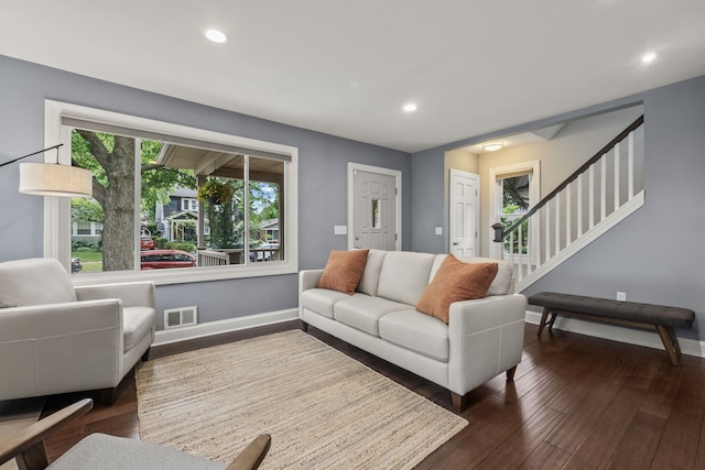 living room with dark wood-type flooring, baseboards, stairs, and recessed lighting