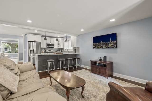 living room with wood finished floors, baseboards, recessed lighting, and plenty of natural light