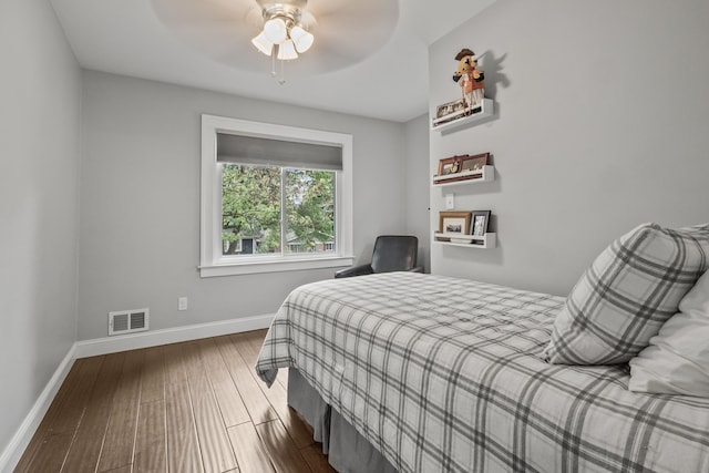 bedroom featuring wood finished floors, baseboards, and a ceiling fan