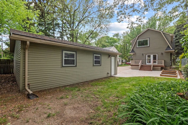 back of property featuring a patio and a wooden deck
