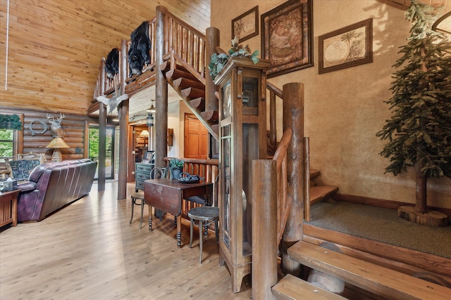 5114 N Oak Rd, Davison, MI 48423 - staircase featuring high vaulted ceiling, log walls, and hardwood / wood-style floors