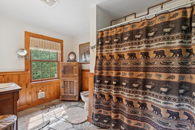 5114 N Oak Rd, Davison, MI 48423 - full bath featuring a wainscoted wall, toilet, vanity, a shower with curtain, and wooden walls