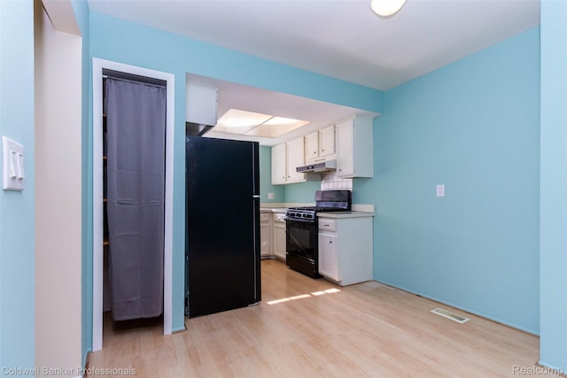 3531 Burbank Dr, Ann Arbor, MI 48105 - kitchen with black appliances, under cabinet range hood, light wood-style flooring, and white cabinets