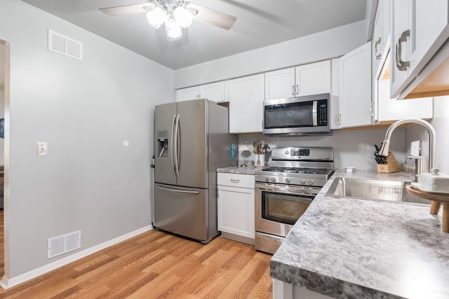 39596 Old Dominion Dr, Clinton Township, MI 48038 - kitchen with stainless steel appliances, a sink, light wood-style flooring, ceiling fan, and white cabinets