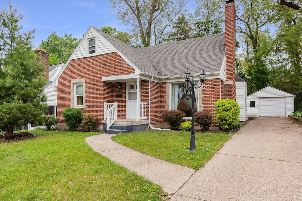 1412 Philadelphia Ave SE, Grand Rapids, MI 49507 - view of front of house featuring a chimney, an outbuilding, a shingled roof, brick siding, and a front lawn