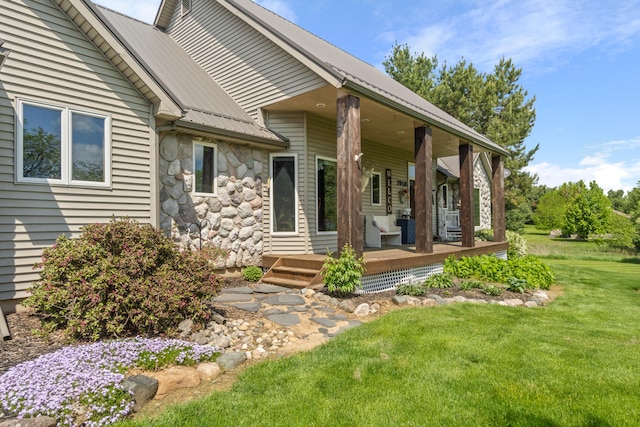 7918 Dan Patch Dr, Jackson, MI 49201 - property entrance featuring metal roof, a yard, stone siding, and a porch