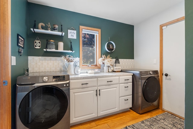 7918 Dan Patch Dr, Jackson, MI 49201 - laundry room with light wood-style flooring, cabinet space, and washing machine and dryer