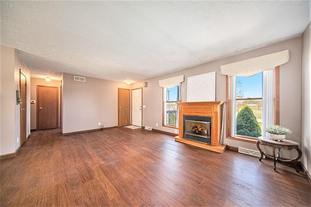 12499 Wilbur Rd, Clinton, MI 49236 - unfurnished living room featuring wood finished floors, a fireplace with raised hearth, baseboards, and a textured ceiling