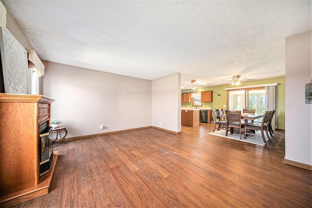 12499 Wilbur Rd, Clinton, MI 49236 - living area with wood finished floors, a textured ceiling, baseboards, ceiling fan, and a fireplace