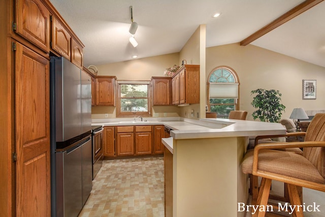 607 Crestview St, Holland, MI 49423 - kitchen with appliances with stainless steel finishes, a peninsula, a breakfast bar, light countertops, and brown cabinets