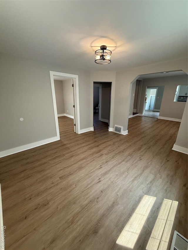 816 12th St, Port Huron, MI 48060 - unfurnished room featuring arched walkways, baseboards, and wood finished floors