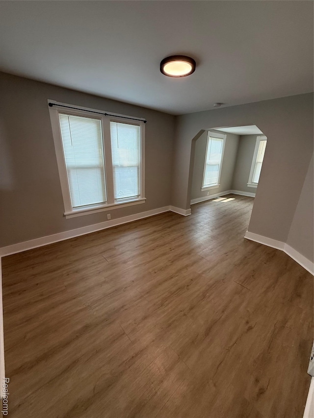 816 12th St, Port Huron, MI 48060 - unfurnished room featuring arched walkways, wood finished floors, and baseboards