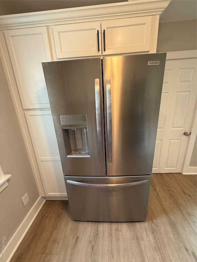 816 12th St, Port Huron, MI 48060 - kitchen view of stainless steel fridge with ice dispenser, light wood-style floors, white cabinets, and baseboards