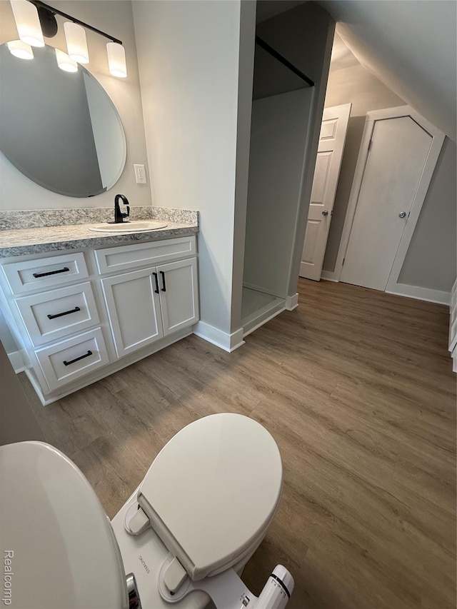 816 12th St, Port Huron, MI 48060 - bathroom featuring vanity, wood finished floors, a stall shower, baseboards, and vaulted ceiling