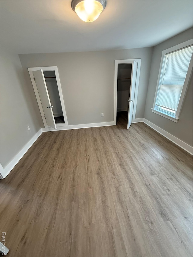 816 12th St, Port Huron, MI 48060 - unfurnished bedroom with wood finished floors, baseboards, a closet, and a spacious closet