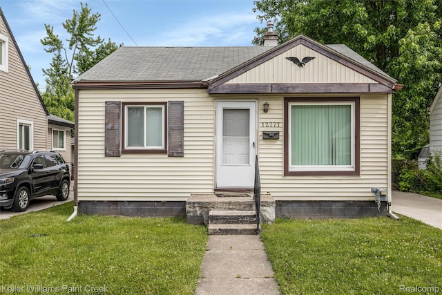 12777 Sherman Ave, Warren, MI 48089 - bungalow with a chimney, a front yard, entry steps, and roof with shingles
