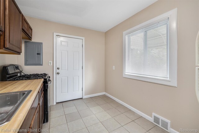 12777 Sherman Ave, Warren, MI 48089 - kitchen with electric panel, stainless steel gas range, light tile patterned floors, baseboards, and a sink