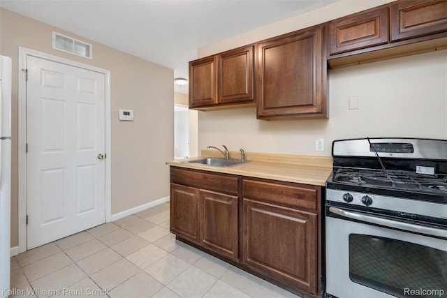 12777 Sherman Ave, Warren, MI 48089 - kitchen with stainless steel range with gas cooktop, a sink, light countertops, light tile patterned floors, and baseboards