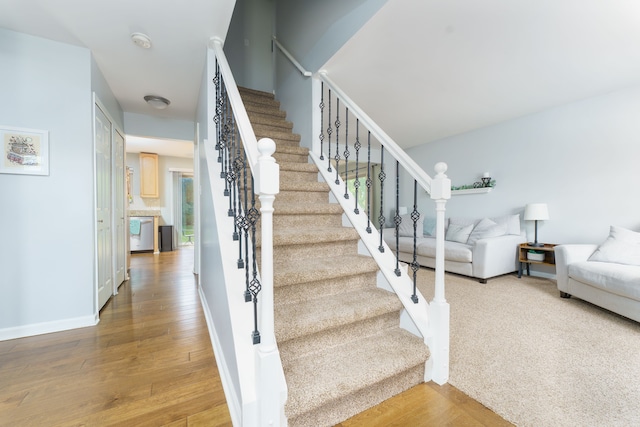 stairway with wood finished floors and baseboards