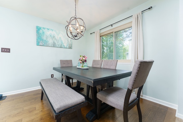 dining room with a chandelier, baseboards, and wood finished floors