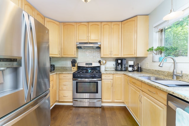 kitchen featuring appliances with stainless steel finishes, light brown cabinets, a sink, under cabinet range hood, and dark wood finished floors