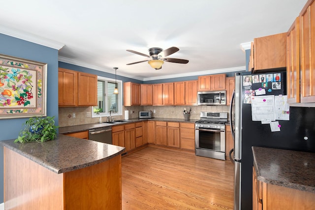 5200 Bridge Trl W, Commerce Twp, MI 48382 - kitchen with appliances with stainless steel finishes, dark countertops, a peninsula, backsplash, and crown molding