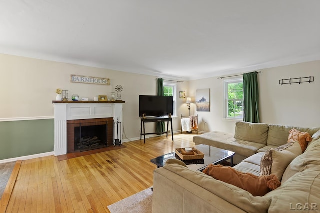 2369 Airport Rd, Adrian, MI 49221 - living room with light wood-style floors, a brick fireplace, and baseboards