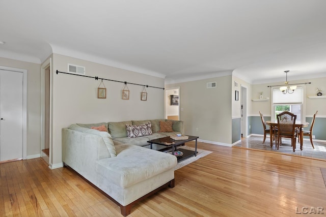 2369 Airport Rd, Adrian, MI 49221 - living room featuring light wood-style floors, a chandelier, and baseboards